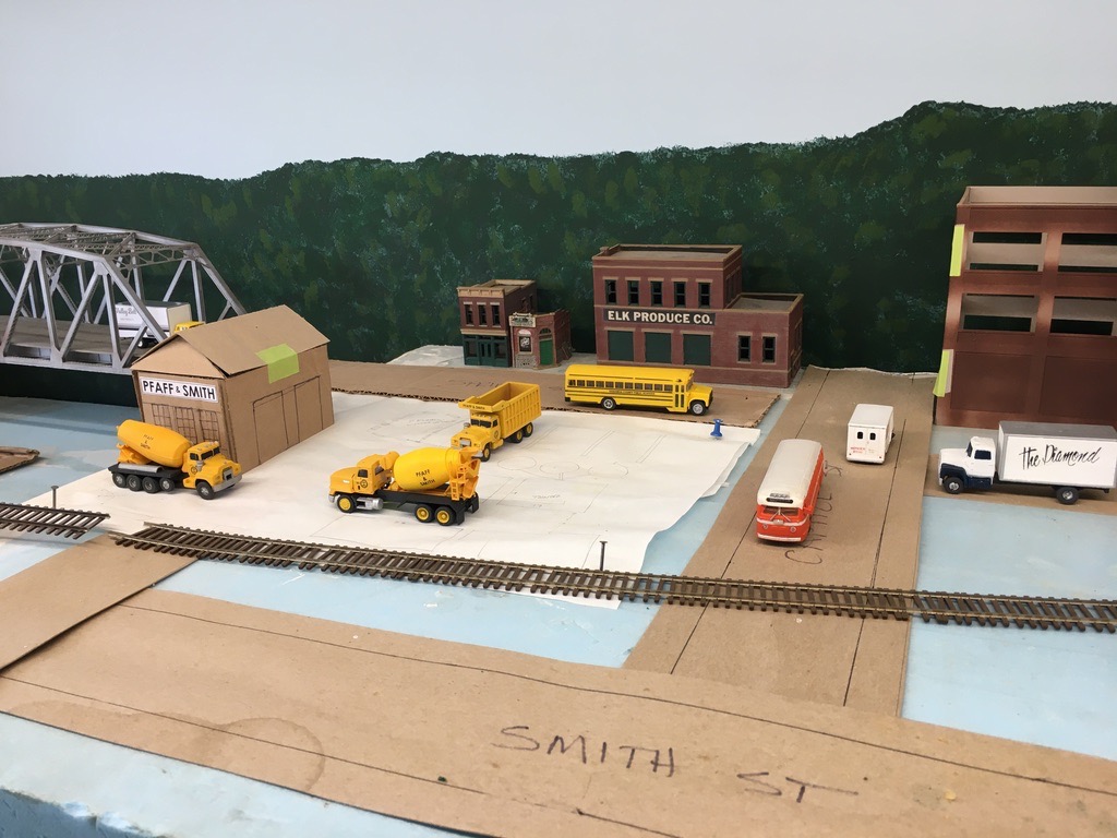 The Diamond was a once thriving department store in Charleston. The cement mixers and dump truck represent vehicles used by Pfaff & Smith. Those vehicles were once painted yellow. The school bus is lettered for Kanawha County Public Schools.