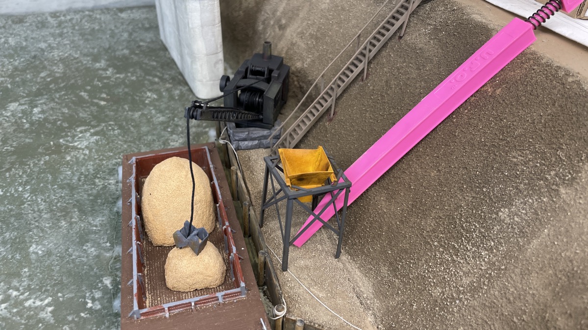 The pink sanding stick is a stand in for a to be built conveyor. It will move sand from barges to the cement plant.